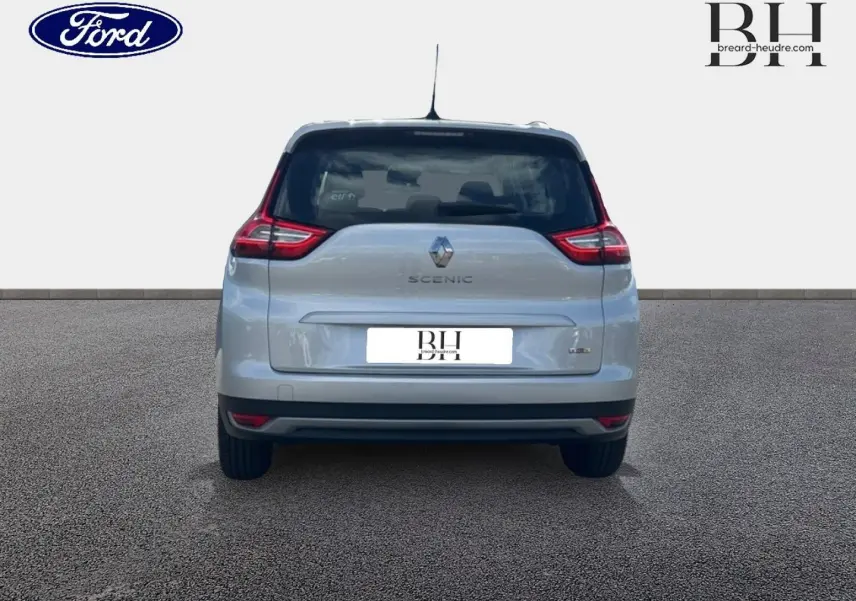 Vue arrière d'un Renault Grand Scenic gris platine, mettant en valeur ses feux arrière distinctifs et son logo central.