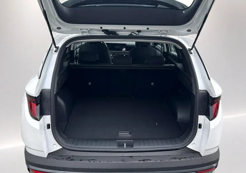Vue arrière ouverte du Hyundai Tucson blanc 2026, mettant en valeur le coffre spacieux et l'intérieur sombre.