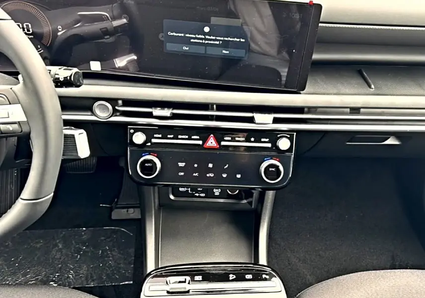 Vue intérieure du tableau de bord et console centrale du Hyundai Tucson 2026 avec écran tactile 12,3 pouces et commandes climatisation.