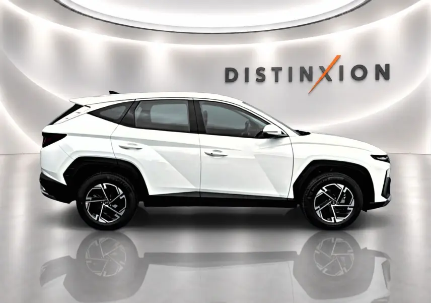 Vue de profil côté gauche du Hyundai Tucson blanc 2026 hybride avec jantes alliage et vitres teintées.