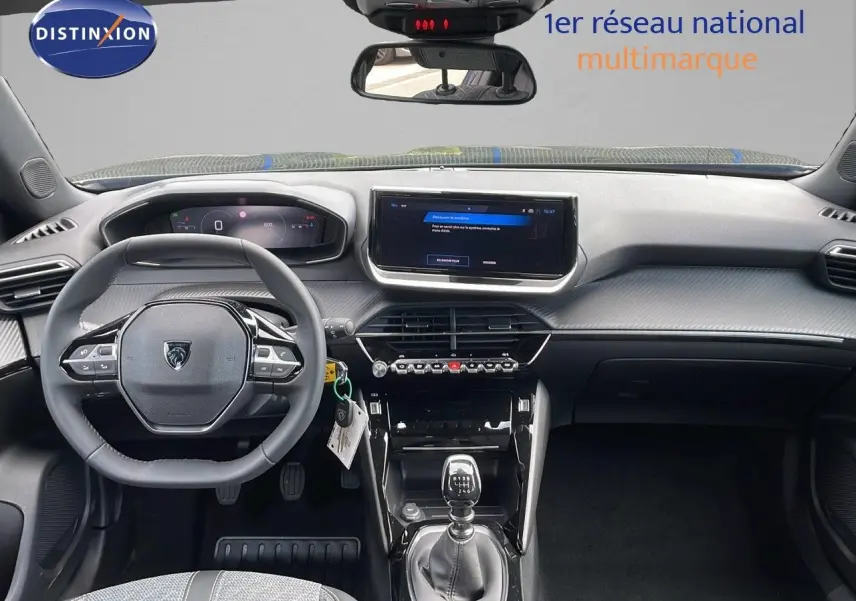 Intérieur de la Peugeot 2008 2025 en vue frontale, tableau de bord moderne avec écran tactile et levier de vitesse manuel.