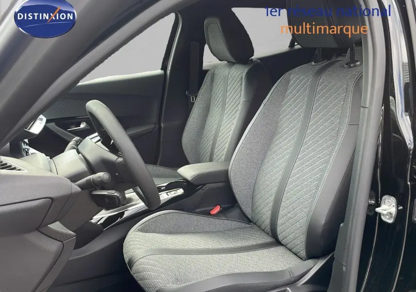 Intérieur de la Peugeot 2008 2025 en noir perla métal, vue côté conducteur sur les sièges tissu et cuir gris.