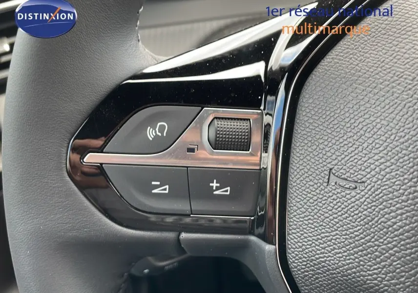 Gros plan sur les commandes du volant du Peugeot 2008 noir, mettant en valeur les boutons de volume et appel.