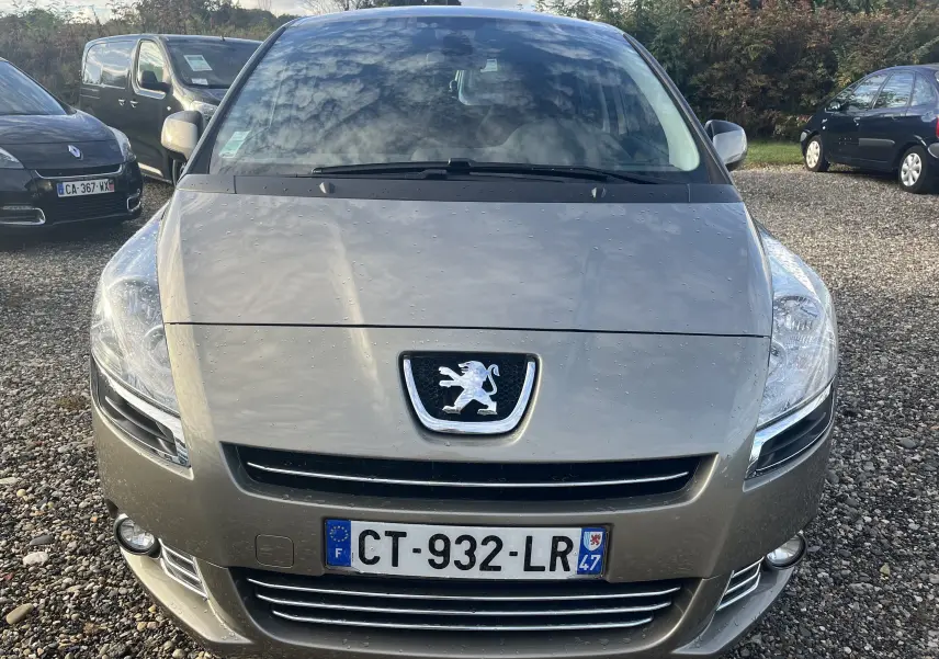 Vue frontale d'un Peugeot 5008 gris métallisé 2013 avec logo lion et plaque d'immatriculation française visible.