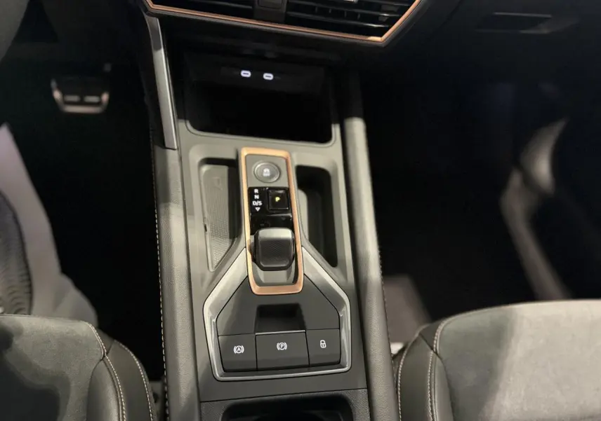 Vue plongeante sur la console centrale noire du CUPRA Formentor 2025 avec levier de vitesses et surpiqûres cuivrées.