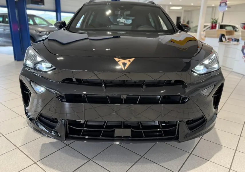 Vue frontale rapprochée du CUPRA Formentor noir Night avec logo cuivré et phares Full LED allumés.