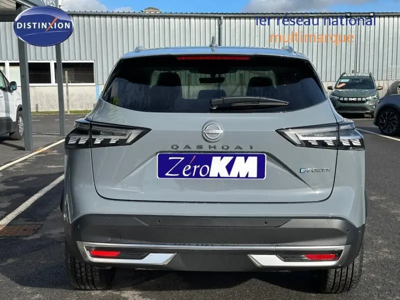 Vue arrière d'un Nissan Qashqai Hybrid e-POWER 2025 en gris Argile avec feux LED et logo e-POWER visible.