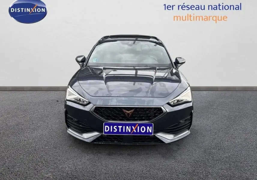 Vue avant frontale d'une CUPRA Leon ST 2024 gris métallisé avec calandre noire et logo distinctif cuivre.