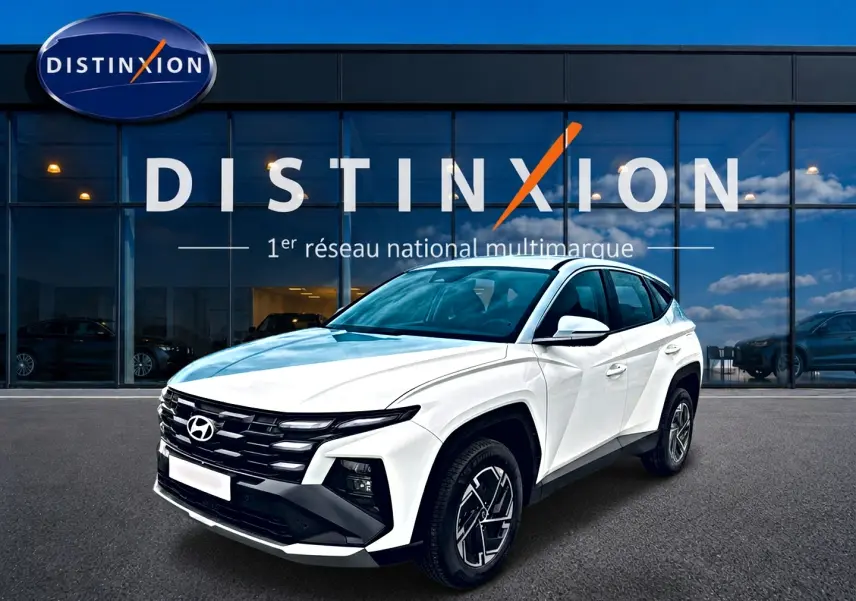 Hyundai Tucson blanc 2026 en 3/4 avant droit, avec calandre noire distinctive et jantes alliage 17 pouces.