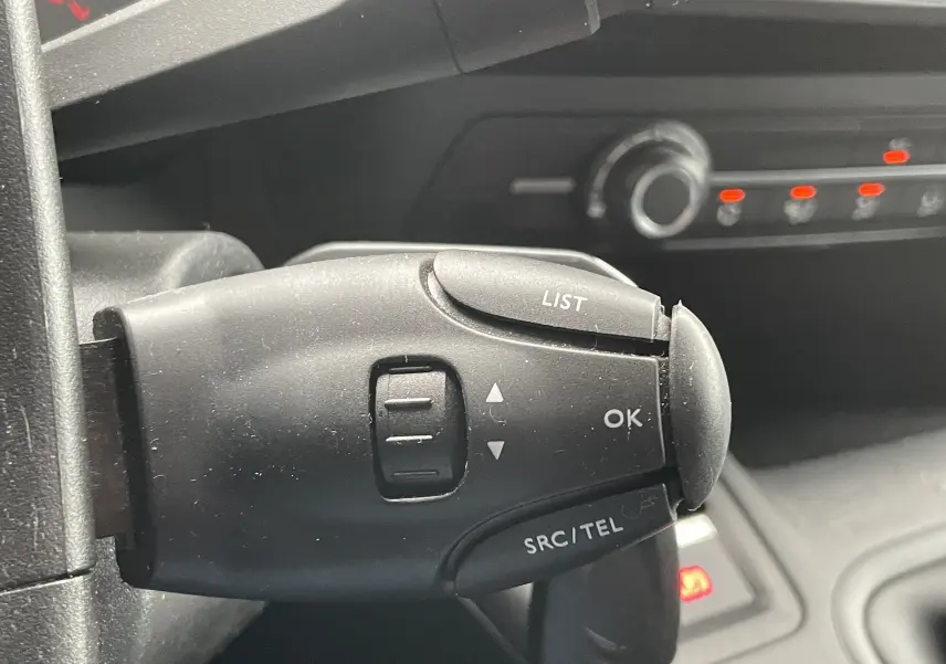 Gros plan sur la commande au volant droite du Citroën Berlingo blanc 2018, avec boutons LIST, OK et SRC/TEL visibles.