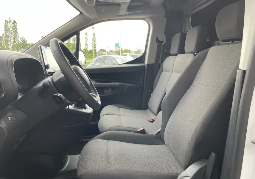 Vue intérieure côté conducteur du Citroën Berlingo blanc 2018, sièges gris et tableau de bord avec écran tactile.