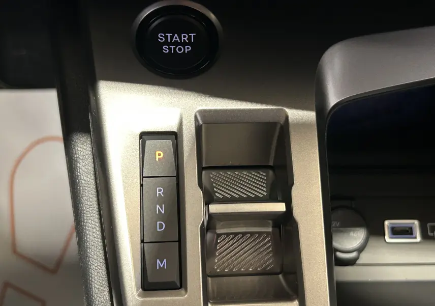 Gros plan sur la console centrale gris métallisé de la Peugeot 308 III Ph.2 GT avec bouton Start/Stop et commandes de boîte auto.