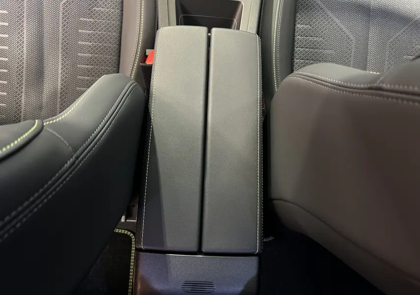 Vue plongeante sur l'accoudoir central en cuir noir avec surpiqûres blanches entre les sièges avant du Peugeot 308 2026.