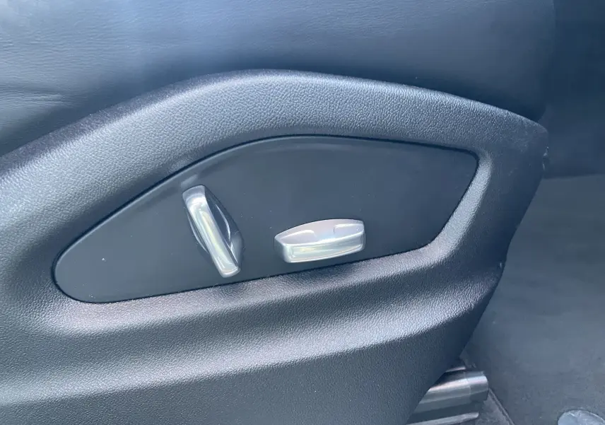 Gros plan sur les commandes électriques de réglage du siège en cuir noir du Porsche Cayenne Coupé E-Hybrid 2021.
