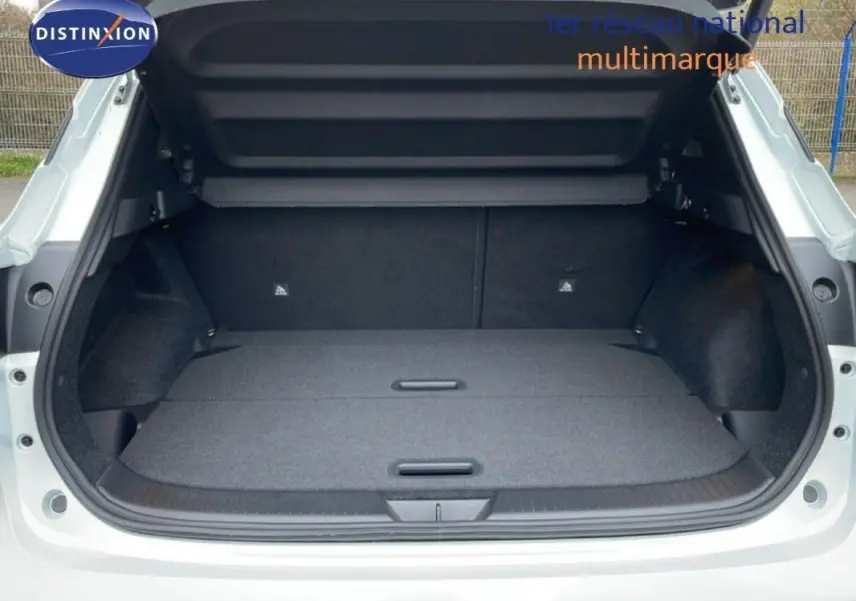 Coffre ouvert vu de l'arrière d'un Nissan Qashqai blanc 2025, montrant un espace de chargement spacieux et plat.