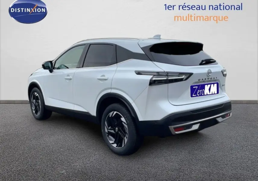 Nissan Qashqai blanc en 3/4 arrière droit, avec jantes aluminium noires et toit noir contrasté.