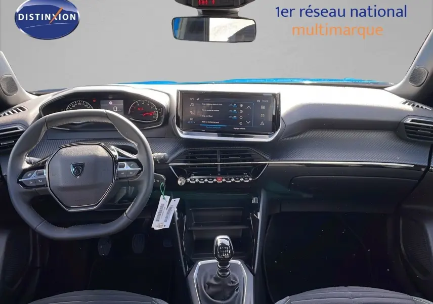 Vue intérieure avant du Peugeot 2008 2024 avec tableau de bord moderne et volant multifonction noir.