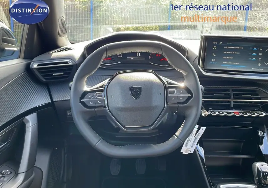 Vue intérieure centrée sur le volant du Peugeot 2008 2024, avec tableau de bord numérique et écran tactile visible.