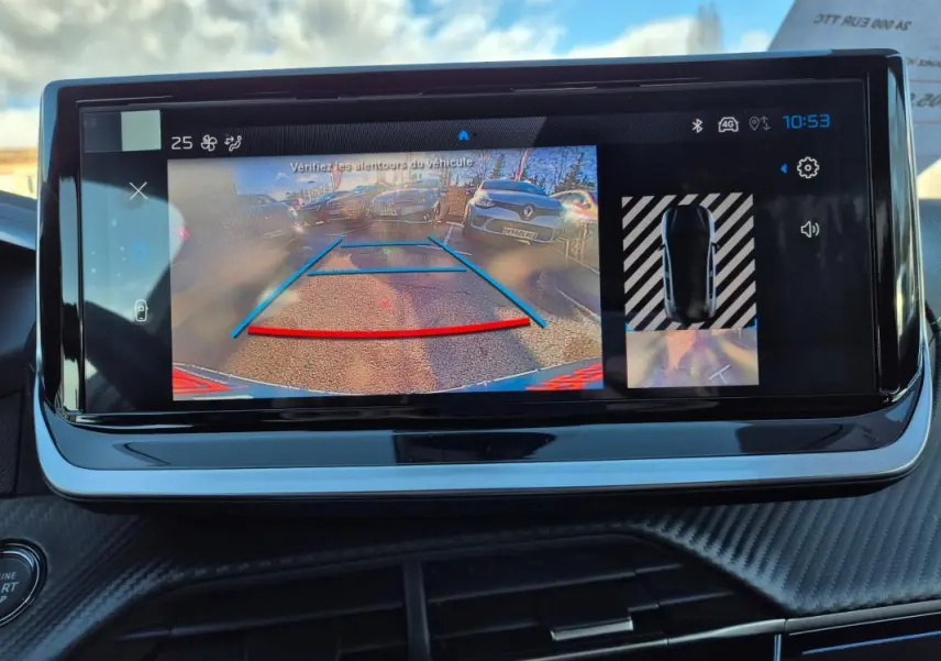 Écran tactile du cockpit numérique affichant la caméra de recul et l'aide au stationnement sur Peugeot 208 blanc.