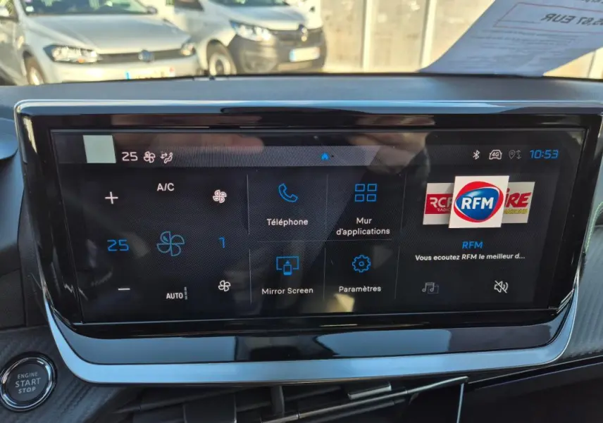 Vue rapprochée de l'écran tactile du tableau de bord de la Peugeot 208 Hybrid 136 e-DCS6 GT, affichant les commandes climatisation et multimédia.