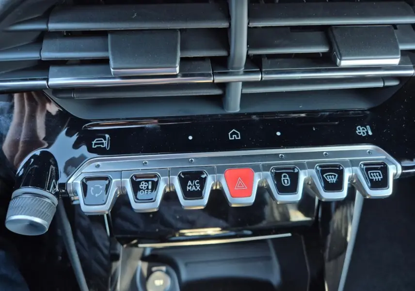 Gros plan sur la console centrale noire brillante de la Peugeot 208 Hybrid 136 e-DCS6 GT 2025, montrant les boutons de commande.
