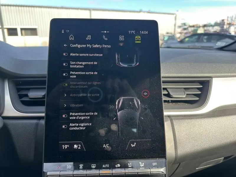 Écran tactile central du tableau de bord du Renault Captur blanc nacré, affichant les options de sécurité et d'alerte.