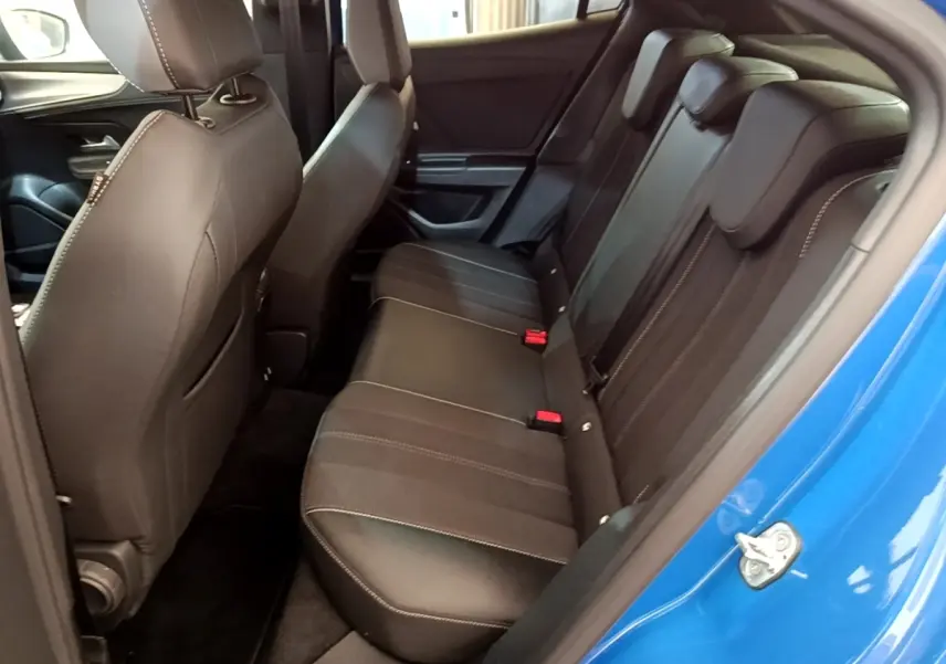 Vue intérieure côté droit sur la banquette arrière noire avec surpiqûres blanches d’un Opel Mokka bleu 2024.