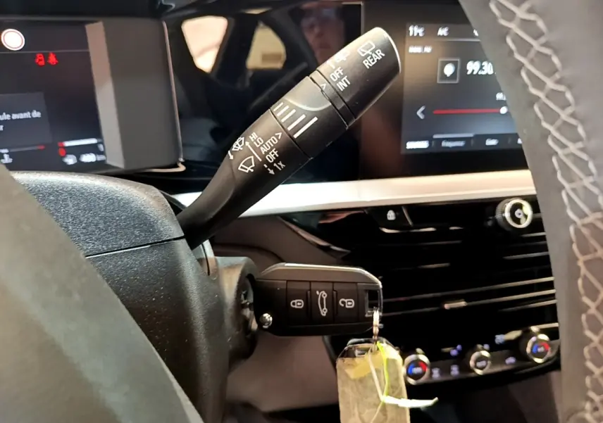 Vue intérieure du tableau de bord de l’Opel Mokka 2024 avec commandes au volant et écran tactile allumé.