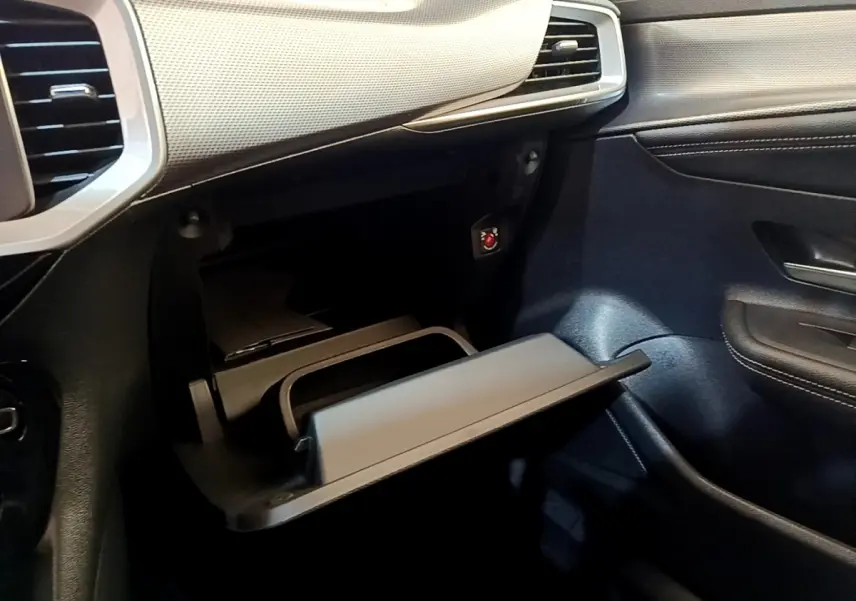 Vue intérieure côté passager de la boîte à gants ouverte du SUV Opel Mokka 2024, avec tableau de bord noir et gris.