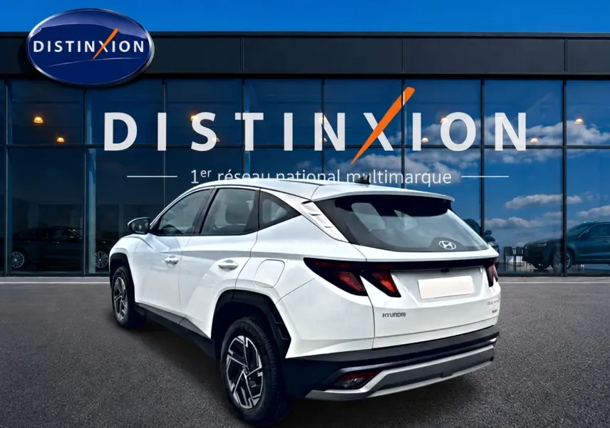 Vue 3/4 arrière droite d'un Hyundai Tucson blanc 2026 avec jantes alliage et feux arrière LED distinctifs.