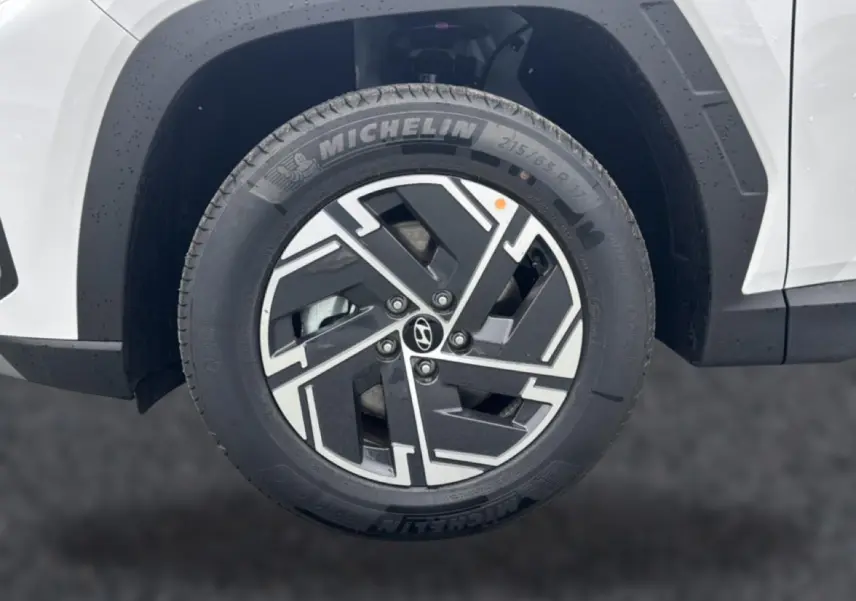 Gros plan sur la roue avant droite blanche du Hyundai Tucson 2026 avec jante alliage noire et argentée.