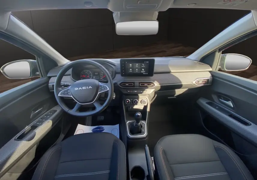 Vue intérieure avant de la Dacia Sandero Stepway 2025, tableau de bord noir avec écran tactile Media Nav et volant multifonction.