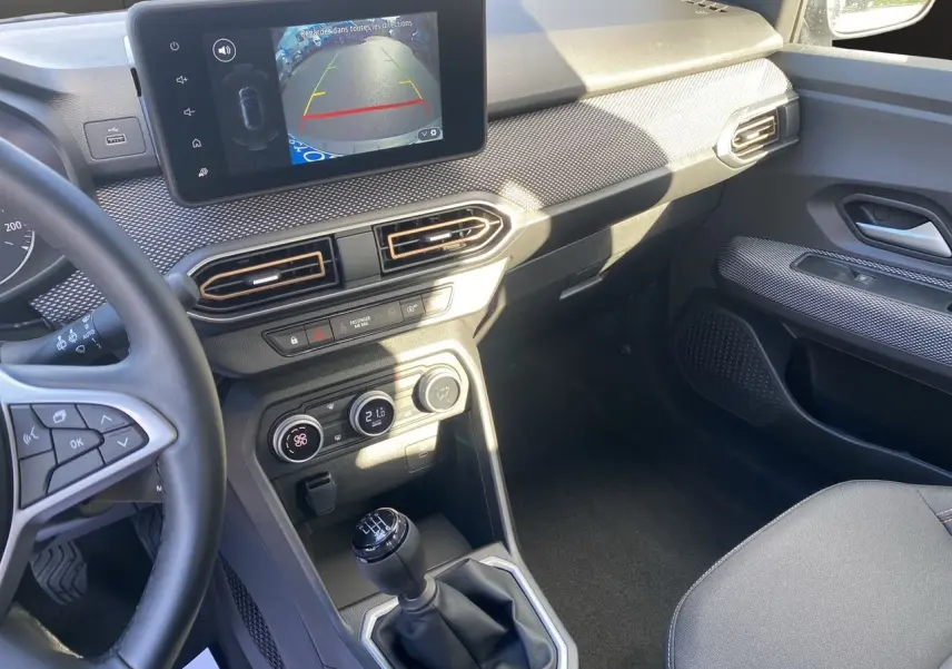 Vue intérieure côté conducteur de la Dacia Sandero Stepway noire, écran Media Nav affichant la caméra de recul et boîte manuelle.