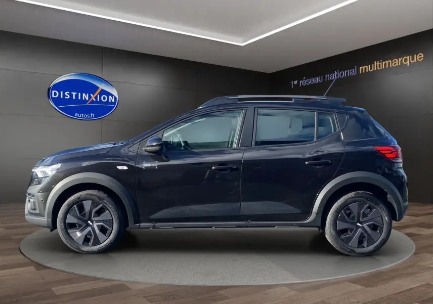Profil côté gauche d'une Dacia Sandero Stepway noire 2025 avec jantes modernes et barres de toit visibles.
