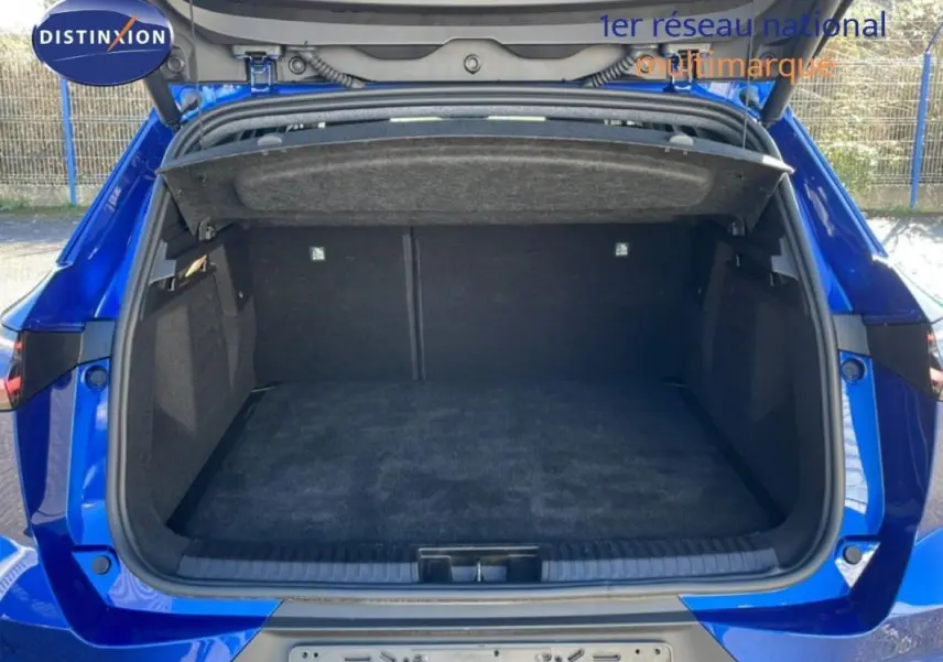 Coffre ouvert vu de l'arrière d'une Renault Symbioz bleu 2025, montrant un espace de chargement spacieux et propre.