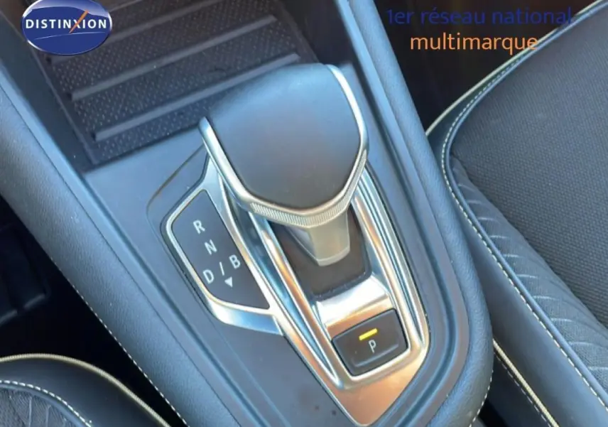 Le levier de vitesses automatique de la Renault Symbioz bleu, vu en gros plan depuis le dessus, avec coutures blanches visibles.