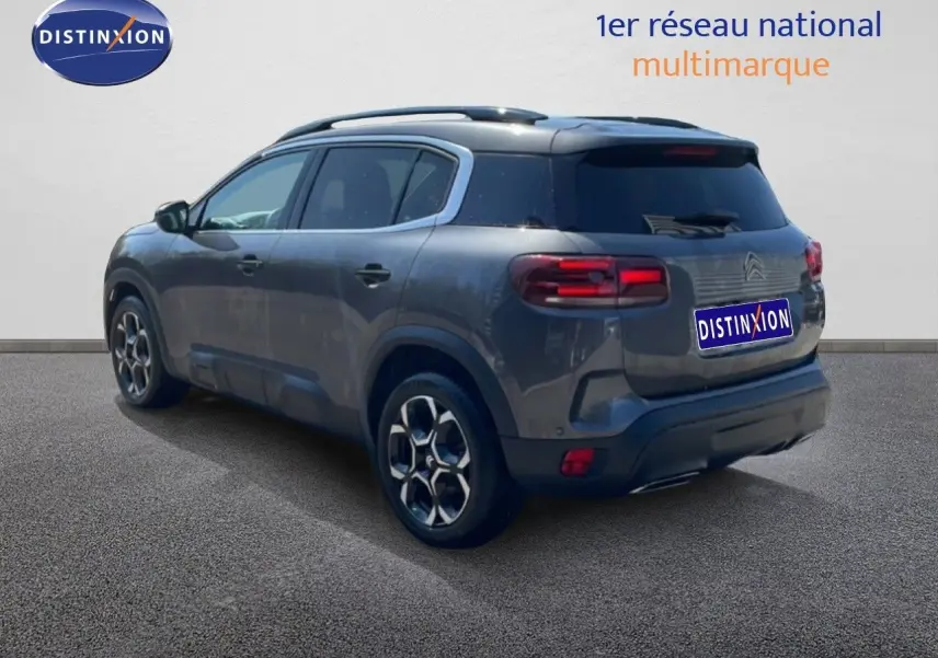 Vue 3/4 arrière droite d'un Citroën C5 Aircross gris platinium métal avec jantes alliage et toit noir.