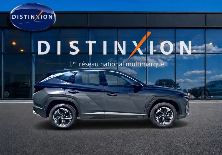 Vue de profil côté gauche du Hyundai Tucson 2026 gris ecotronique avec jantes alliage et lignes anguleuses marquées.