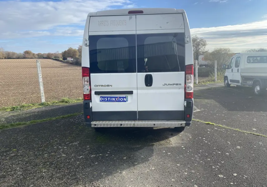 Vue arrière d'un utilitaire blanc Citroën Jumper L3H2 2011 avec marquage "ARRÊTS FRÉQUENTS" sur la porte supérieure.