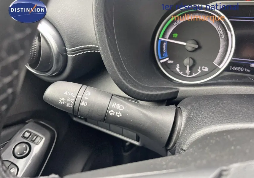 Gros plan sur la commande des phares et clignotants à gauche du volant du Nissan Juke blanc nacré 2024 hybride.