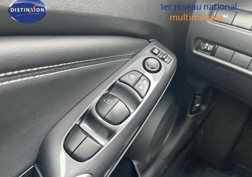 Gros plan sur les commandes électriques de la porte côté conducteur du Nissan Juke blanc nacré 2024.