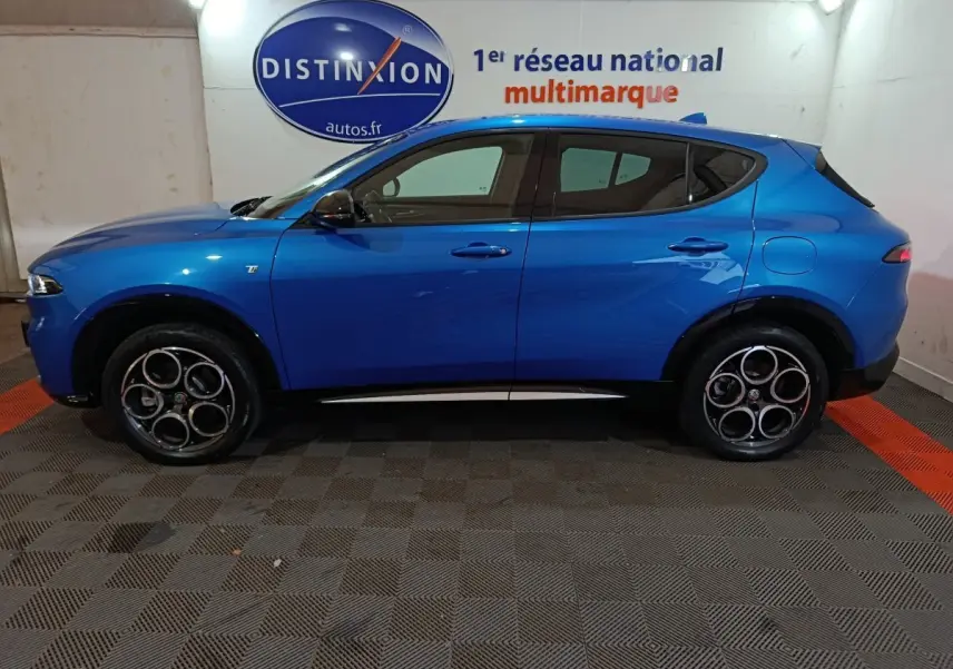 Vue de profil côté gauche d'un Alfa Romeo Tonale bleu 2023 avec jantes distinctives et logo Ti sur la porte avant.