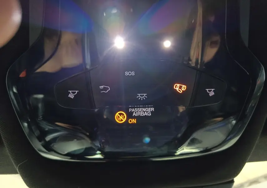 Vue en gros plan du panneau de commande intérieur avec éclairage et indicateur airbag passager activé sur Alfa Romeo Tonale bleu.