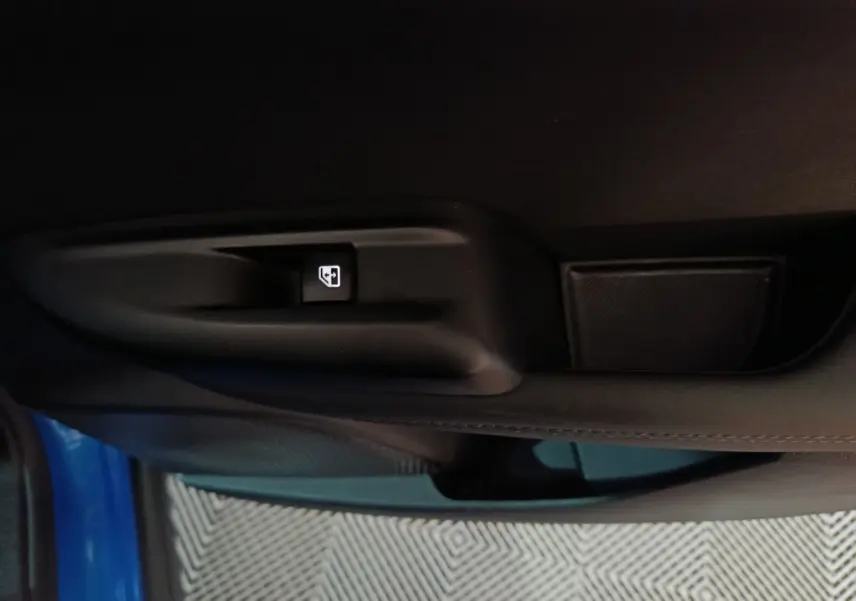 Détail de la commande de lève-vitre sur la porte côté gauche d’une Alfa Romeo Tonale bleu 2023.