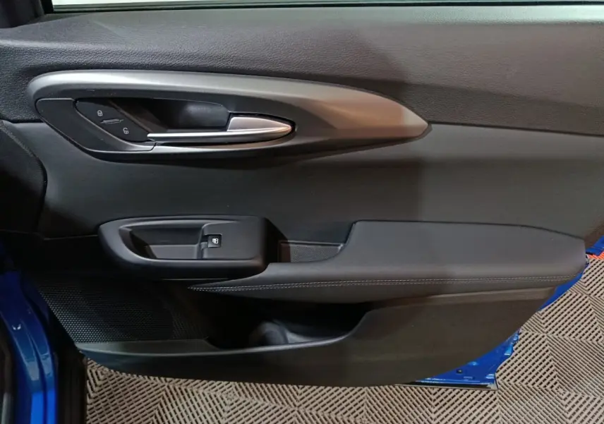 Détail de la porte côté gauche de l'Alfa Romeo Tonale bleu 2023, avec poignée argentée et commandes de verrouillage.