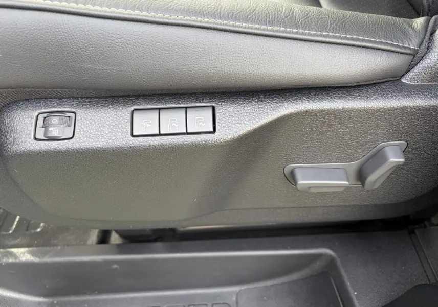 Détail des commandes de réglage électrique du siège conducteur en cuir noir du Citroën Jumpy gris acier.