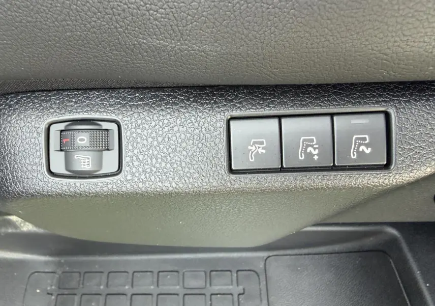 Gros plan sur les commandes de réglage des sièges chauffants et électriques dans un Citroën Jumpy gris acier.