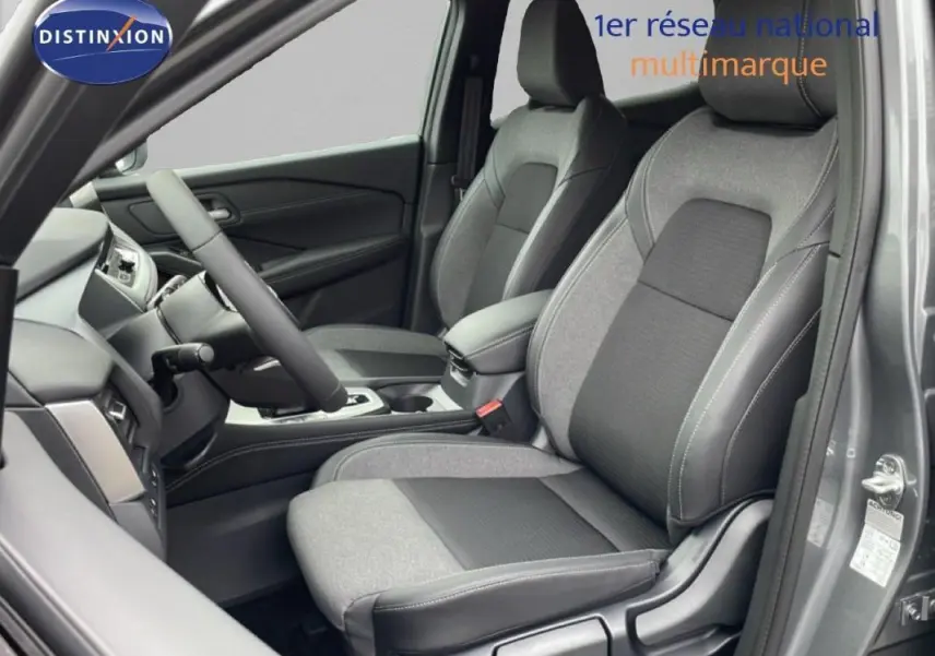 Vue intérieure côté conducteur du Nissan Qashqai gris 2025, mettant en valeur les sièges bi-matière et le volant cuir.
