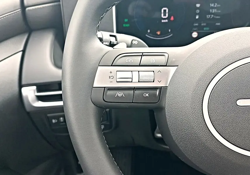Gros plan sur le volant cuir multifonction gris du Hyundai Tucson 2026 avec commandes intégrées et tableau de bord numérique.