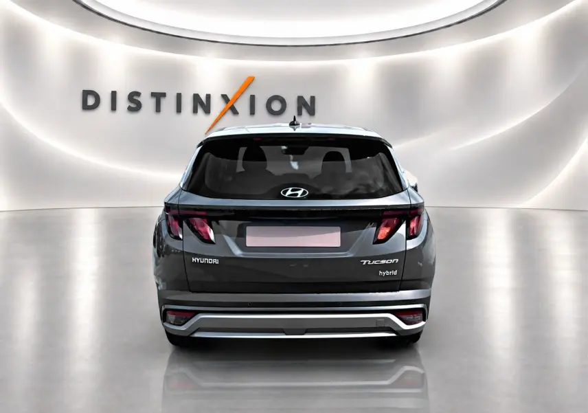Vue arrière d'un Hyundai Tucson gris ecotronique hybride, avec feux arrière LED et logo Hyundai visible.